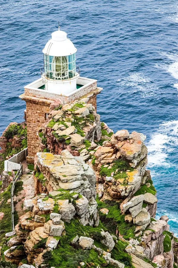 Lighthouse on the rocky headland at Cape Point, seen from above with the open ocean beyond