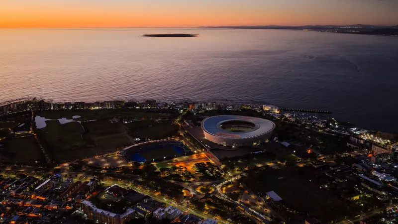 Aerial view of Cape Town Stadium and the Atlantic coastline at sunset
